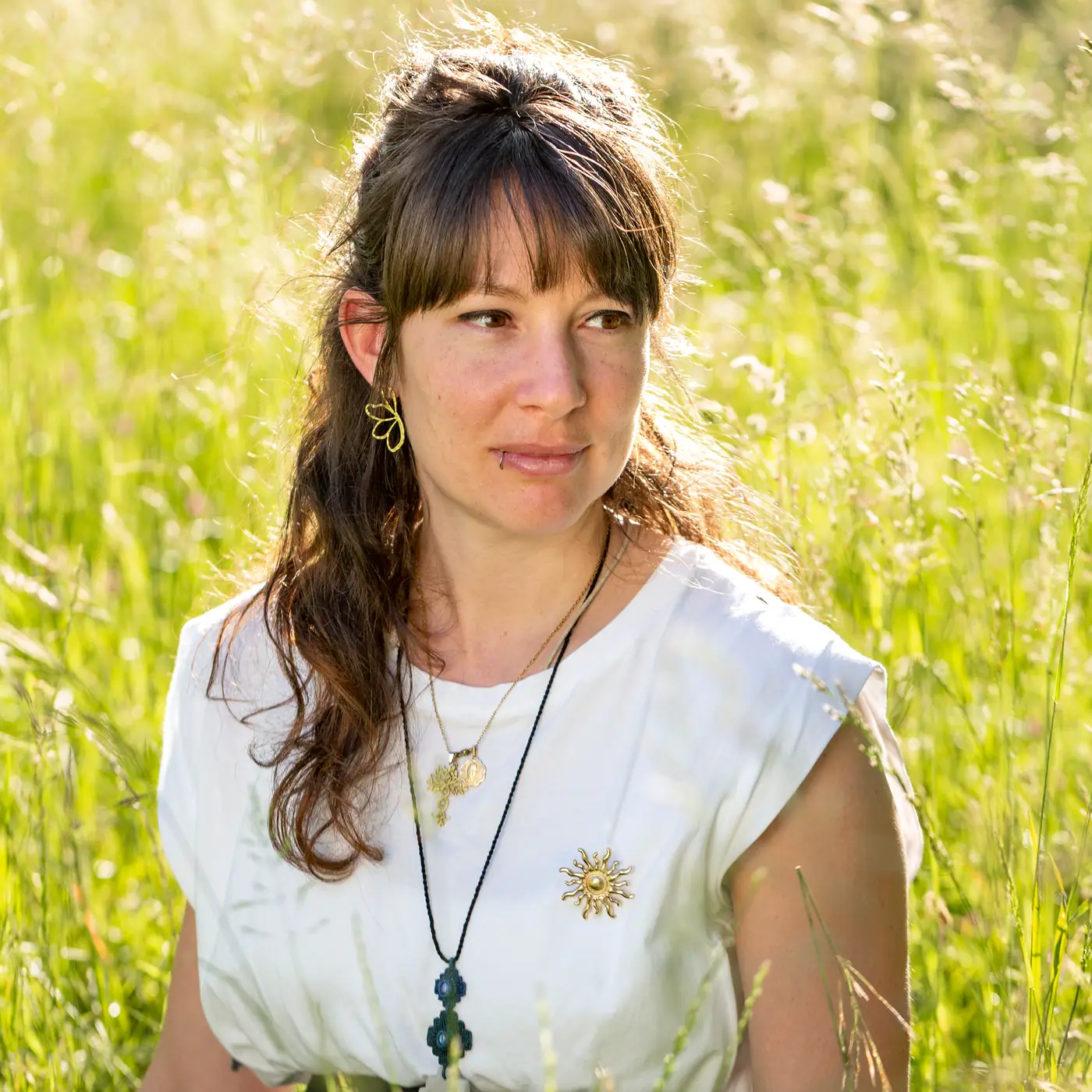 Camille Petit, naturopathe et magnétiseuse à Gières, dans une prairie ensoleillée